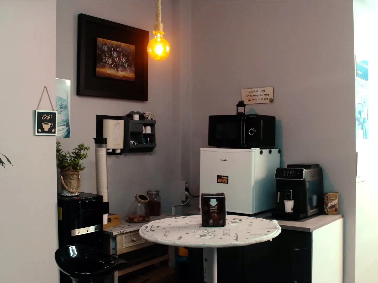 Zona de café com mesa alta, máquina de café e candeeiro